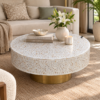 Round mother of pearl coffee table with white floral inlay pattern and brass base
